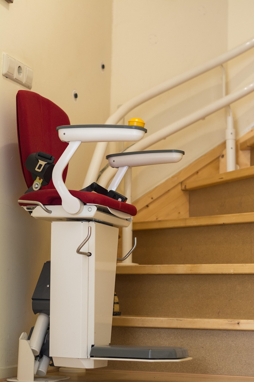 Personne âgée descendant un escalier en pierre avec une canne, illustrant le besoin de mobilité verticale.